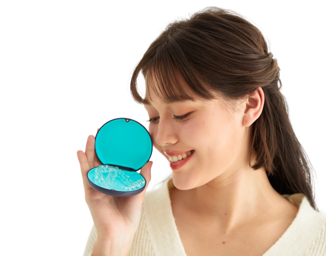 Smiling woman holding Dr Clear Aligners case, symbolizing confidence and lifetime smile guarantee in Malaysia