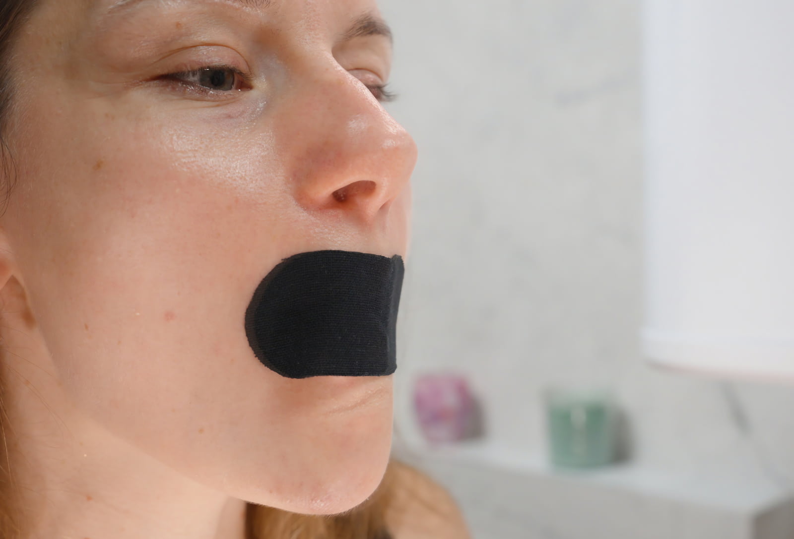 Person using mouth tape while sleeping as a mouth breathing habit example